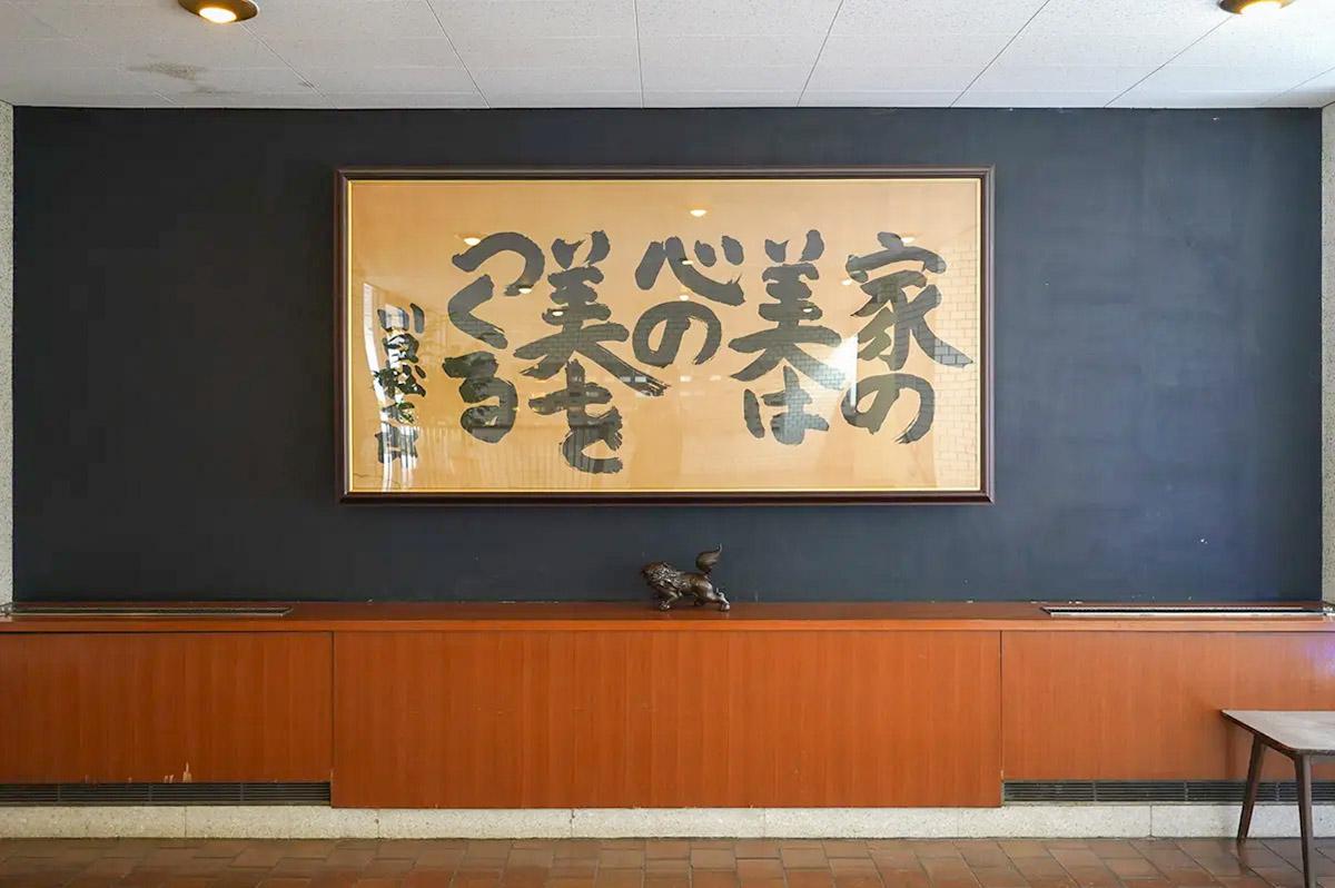 文京区春日の賃貸物件/エントランスには川口松太郎による書が。力強いタッチで書かれたこのメッセージがこの建物のアイコン