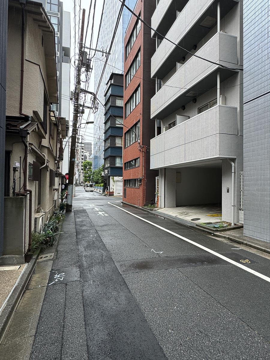 港区芝の賃貸物件/前面道路の様子。オフィスビルや古い戸建てが立ち並ぶ不思議な通り