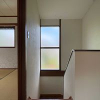 西東京市柳沢の賃貸物件/階段のガラスから見える空の青と緑