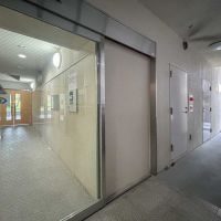 墨田区向島の賃貸物件/1階エレベーター前。写真左手のエントランスホールには宅配ボックスがあり、右手にはごみ捨て場や住人用の勝手口があります