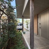 練馬区大泉学園町の売買物件/車の後方からアプローチを眺める、玄関のすぐそばにある右の扉からキッチン裏の倉庫に直接出入りできます