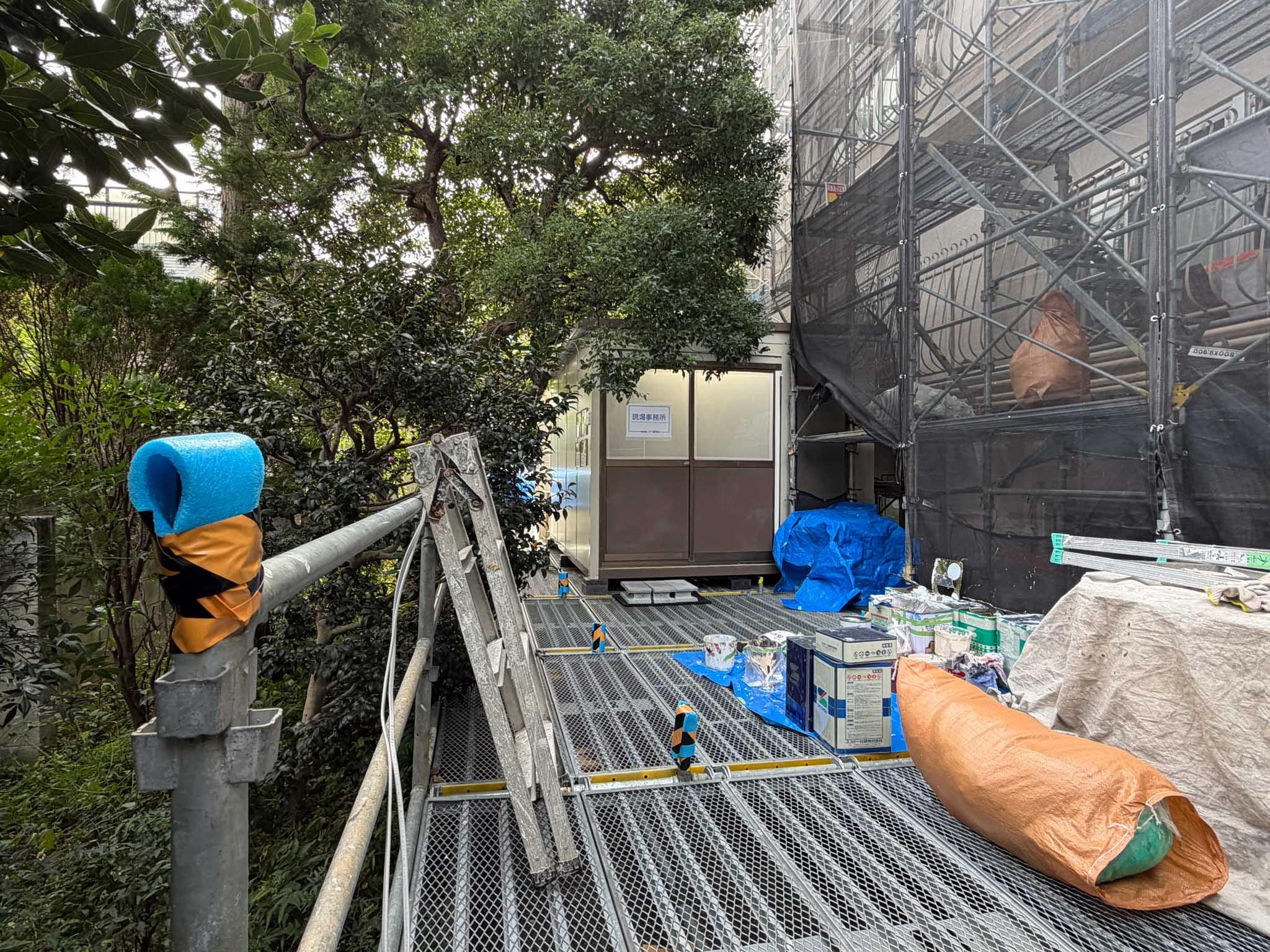 目黒区東が丘の賃貸物件/部屋の外（東側）。足場と工事関連の小屋が撤去されれば、日当たりとともに植栽の緑が見えるようになります