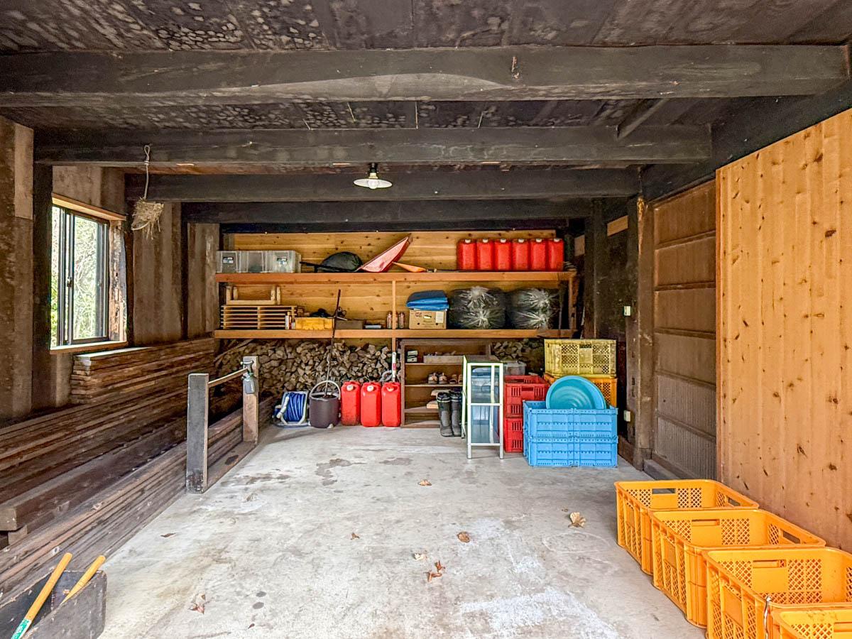 長野県上水内郡信濃町富濃の売買物件/倉庫は、工具やタイヤ、草刈り機、雪囲いなどを収める実用的な収納スペースとして使われています。小型車や軽自動車の駐車も可能です