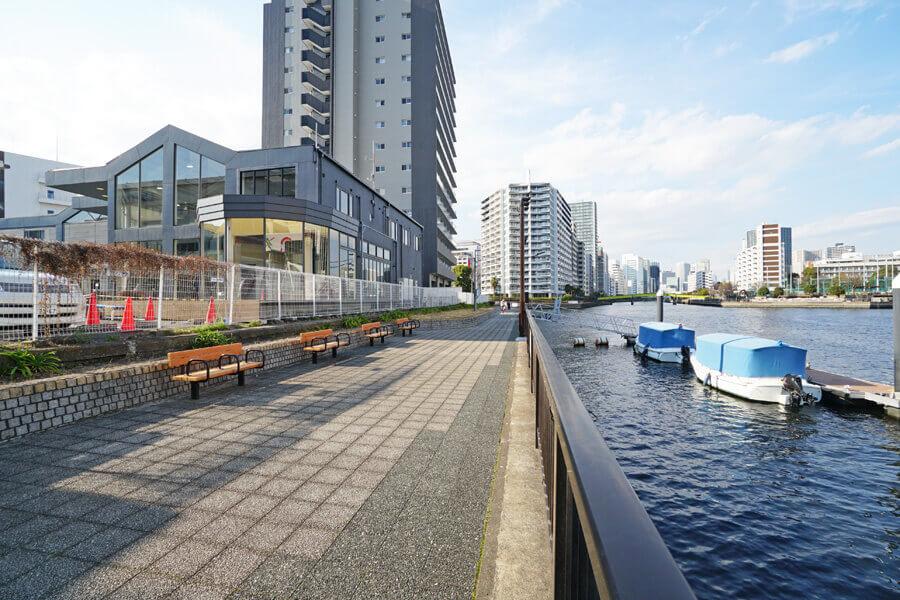 品川区東品川の賃貸物件/写真左側が建物。運河沿いは遊歩道になっていて、ベンチもあります
