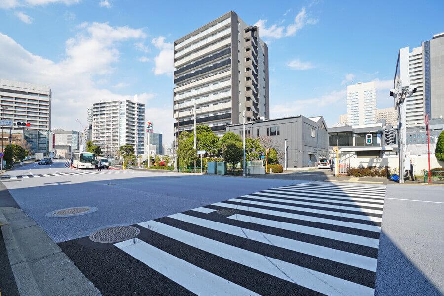 品川区東品川の賃貸物件/写真真ん中のグレーの建物が物件。交通量のある道路に面しています