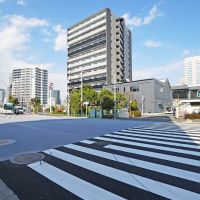 品川区東品川の賃貸物件/写真真ん中のグレーの建物が物件。交通量のある道路に面しています
