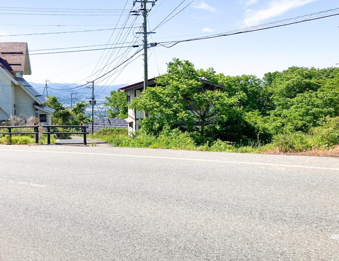 山形県山形市蔵王上野の売買物件/県道21号/蔵王国定公園線から見た様子：真ん中のちょっと木陰に隠れた白い家（が建っている土地）です